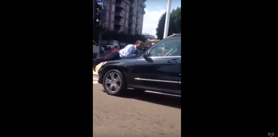 Daring Husband Tries to Reason With His Wife While Hanging on to the Hood of Her Car [WATCH]