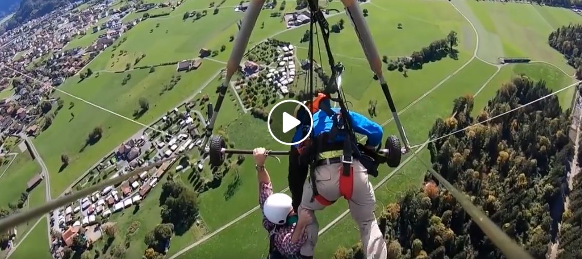 Hang-gliding passenger holds on for dear life after realizing harness not attached