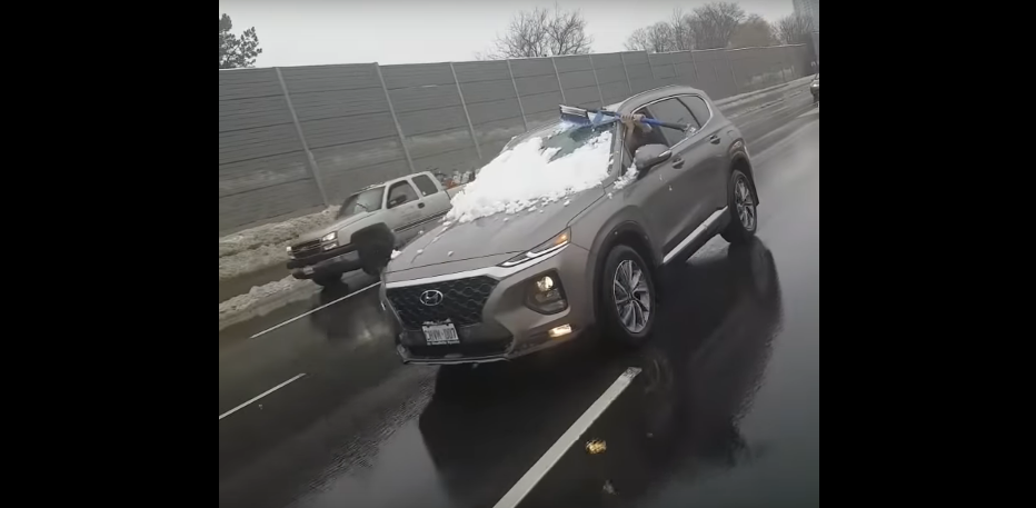Watch a Woman Clean Snow Off Her Car While Driving on the Highway [VIDEO]